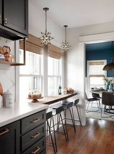 an open kitchen and dining room with wood floors, blue walls and white countertops