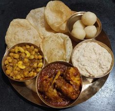 a metal plate topped with different types of food on top of a black countertop