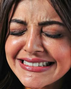 a close up of a woman smiling with her eyes closed