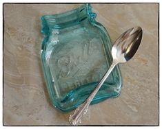 a glass jar with a spoon sitting on top of it