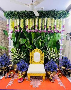 a yellow chair sitting on top of a red rug next to purple and white flowers