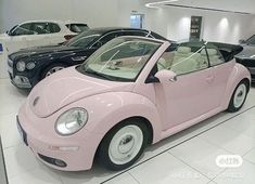 a pink car is parked in a showroom