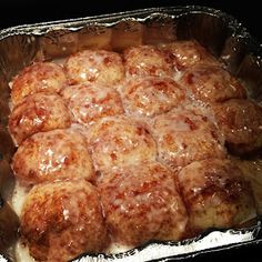 a pan filled with meatballs covered in gravy on top of aluminum foil