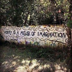 graffiti on the side of a fence that says worry is a misuse of imagination