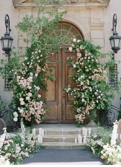 an entrance to a building with flowers growing on the door and steps leading up to it