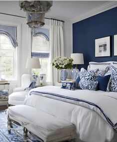 a bedroom with blue walls and white furniture