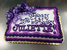 a purple and white birthday cake on a table