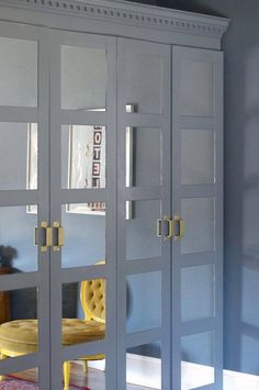 an image of a bedroom setting with mirrored closet doors and yellow chair in the corner