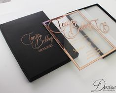 the inside of a black and gold wedding album with rose gold foil lettering on it