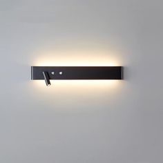 a wall mounted light on the side of a white wall