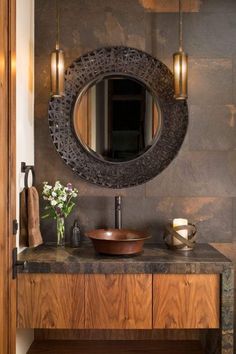 a bathroom sink sitting under a round mirror