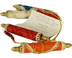 two red and gold decorated wooden dolls next to a paper with a message on it