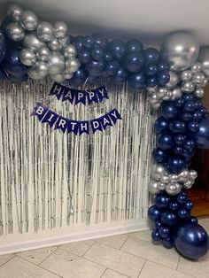 balloons and streamers decorate the entrance to a birthday party with blue and silver decorations