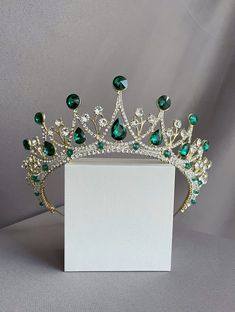 "You have a great opportunity You can buy earrings complete with this crown for only $ 7 Beautiful sparkling tiara with emerald stones in gold plated. This wonderful tiara is for true queens. This crown is suitable for any event. Such as a ball, a wedding, a photo session, themed parties, etc. It will look great on the bride. I'm sure you will get a lot of compliments. A spectacular tiara fit for an extremely elegant woman on her wedding day!  All my handmade jewelry with the best materials for Emerald Crown Queens, Royal Green Wedding Theme, Quince Crowns, Emerald Crown, Emerald Tiara, Tiara Royal, Quinceanera Jewelry, Quinceanera Crown, Tiara Headpieces