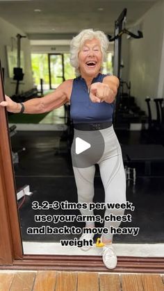 an older woman is standing in front of a doorway with her arms out and pointing at the camera