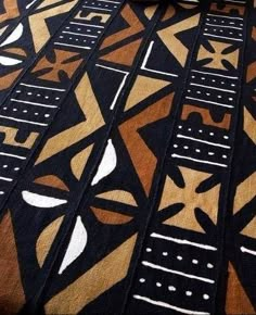 a close up of a black and brown rug with white designs on the floor next to a window