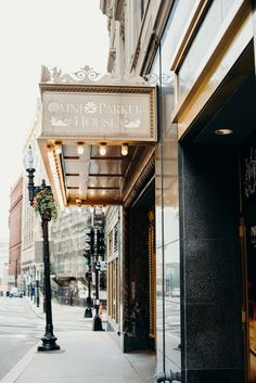 a street sign on the side of a building next to a lamp post and sidewalk