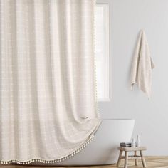 a bath room with a laptop and a shower curtain in front of a white wall