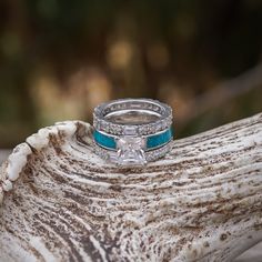 This is our Women's Engagement and Wedding Set. 3 rings included. Features a beautiful stacked ring arrangement with a 5mm Women's Genuine Crushed Turquoise Ring with 1.4 Carat, square stone Cubic Zirconia, and two of our beautiful Baguette Stacking bands with Cubic Zirconia Stones arranged throughout. ABOUT THIS RING (1) The Grand Sierra (Engagement Band) Material: 925 Sterling Silver or Titanium, Genuine Crushed Turquoise*, Resin Coating Stones: 1.4 Carat Cubic Zirconia (CZ) Stone Color/Finish Weddin Rings, Ring Arrangement, Square Wedding Rings, Fashion Ring Set, Western Rings, Turquoise Resin