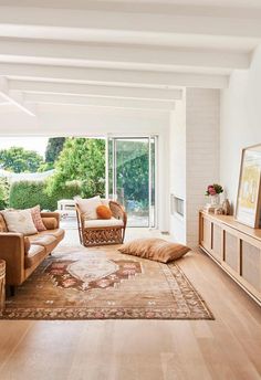 a living room filled with furniture and a large rug on top of a hard wood floor