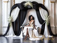 a woman sitting on a chair in front of a black and white backdrop with flowers