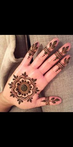 a woman's hand with henna tattoos on it