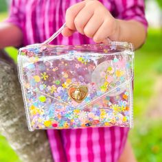 In the South, getting Gussied Up means you are gorgeous and extra fancy. When your sister has the same nickname, she gets her own handbag... filled with sparkles and joy and all the best things. She also comes with a matching cross-body strap and yes, the strap is filled with sparkle too! Gussie Multi Sparkle has all of the colors of the rainbow in flowers and sprinkles. Lightweight, durable, clean with a wet cloth. 6.5” x 6.5” x 2” Cute Shoulder Bag For Spring Party, Cute Crossbody Satchel Gift, Cute Party Shoulder Bag With Adjustable Strap, Cute Party Bag With Adjustable Strap, Cute Handheld Shoulder Bag For Party, Cute Party Bags With Adjustable Strap, Fun Crossbody Gift Bags, Cute Handheld Satchel As Gift, Trendy Glitter Bags For Gifts