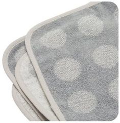 two gray and white polka dot towels on top of each other