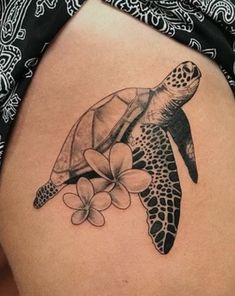 a woman's thigh with a turtle and flowers on it