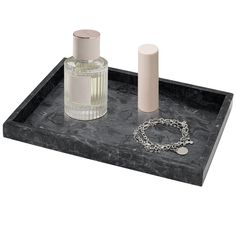 a black tray with two bottles and a chain on it