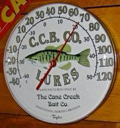 a thermometer with a large fish on it's face and words above it