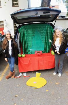 two girls standing next to an open trunk