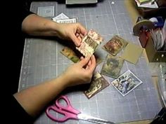 a person cutting up some cards on a table with scissors and other items around them