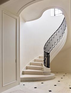 a white staircase with black handrails leading up to the second floor