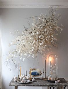 a table with candles, plates and flowers on it