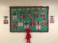 a green bulletin board with christmas decorations on it and a red ribbon hanging from the wall