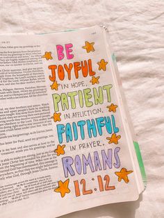 an open bible with the words be joyful in hope, patient in affection, and faithful in prayer