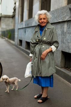 an old woman walking her dog down the street