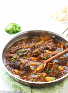 a pot filled with meat and beans on top of a table