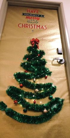 a christmas tree made out of tinsel is on the wall in front of a door