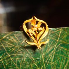 An ethereal art nouveau 14k yellow gold seed pearl accent flower pin from the Victorian era. Featuring a line engraved gold flower with a pearl seed pistil and whimsical leaves that frame the petaled flower. It looks as if one of the gold petals has broken off, unfortunately, but it doesn't seem to affect the overall look of the piece. The brooch has a horizontal brooch pin with a 19th c-clasp. The back of the pin is marked 14k and the gold has been tested for authenticity. In great vintage cond Art Nouveau Yellow Gold Brooches Gift, Gold Art Nouveau Brooch For Collectors, Art Nouveau Yellow Gold Collectible Brooches, Gold Art Nouveau Brooches For Gift, Art Nouveau Gold Brooches As Gift, Art Nouveau Wedding Brooches Hallmarked, Art Nouveau Gold Flower Jewelry, Whimsical Leaves, Victorian Brooch