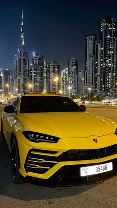 a yellow sports car parked in front of a city skyline