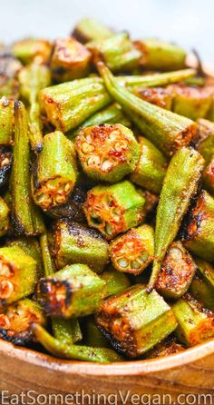 cooked green beans in a wooden bowl with seasoning sprinkled on the top