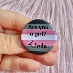 a hand holding a button with the words are you a girl? kinda