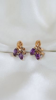 * Earring Material: Amethyst, Diamond, 14K Yellow Gold  * Earring Dimensions:0.6x0.4 Inch, Short Length Post  * Stone Weight & sizes: Amethyst - 0.40ct, Diamond - 0.04ct  * Earring material: 14k yellow gold, Post Push Back  * Overall weight: 3.2g 14k Gold Purple Earrings With Prong Setting, Purple 14k Gold Earrings With Prong Setting, Elegant Purple 14k Gold Earrings, Luxury Amethyst Earrings With Prong Setting, Elegant Oval Amethyst Earrings, Elegant Gold Amethyst Crystal Earrings, Amythest Stud Earrings, Gold Earring, Diamond Stud Earrings