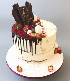 a white cake with chocolate and strawberries on top