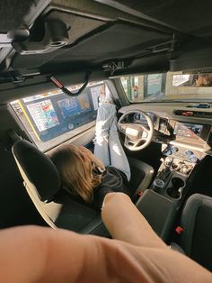 a person sitting in the driver's seat of a car with their feet up