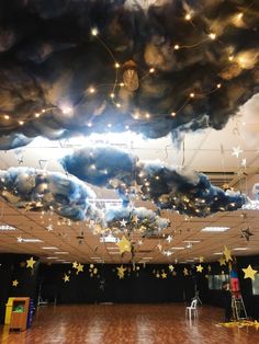 a large room with stars and clouds hanging from it's ceiling in the center