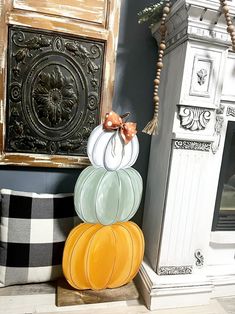 decorative pumpkins stacked on top of each other in front of a fireplace mantel