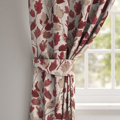 the curtains are hanging on the window sill in front of the window with red flowers